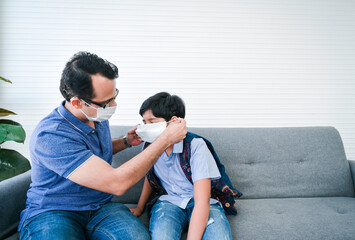 Indian father help his son wearing medical mask to protect Coronavirus covid-19 infected and he teach his son for the method to complete wearing the medical mask.