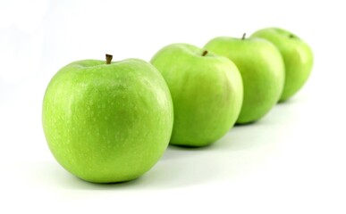 Green apples Granny Smith  in a row on white background.