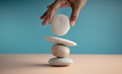 Life Balance Concept. Hand Setting White Natural Zen Stone Stack. Balancing Mind, Soul and Spirit....