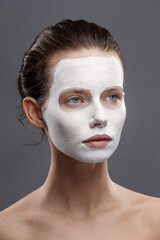 Beautiful girl is applied a white cosmetic mask from black dots. Isolate, studio