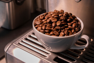 A cup of roasted coffee beans on a coffee machine