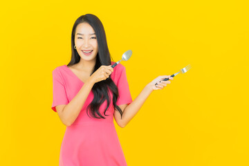 Portrait beautiful young asian woman smile with spoon and fork
