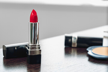 New red lipstick on vanity table close up
