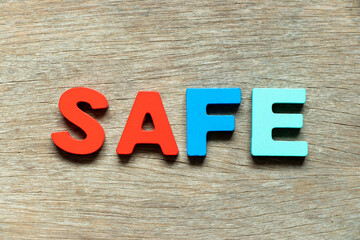 Fototapeta premium Color alphabet letter in word safe on wood background
