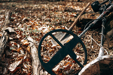 Metal detector device and spade on ground in forest