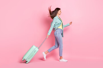 Full length profile side photo of charming pretty young lady walk empty space travel bag isolated...