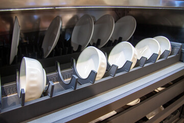 White dishes on the contemporary plastic shelves in the kitchen cupboard