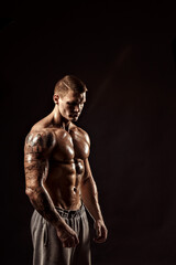Studio portrait of a shirtless athletic tattooed male