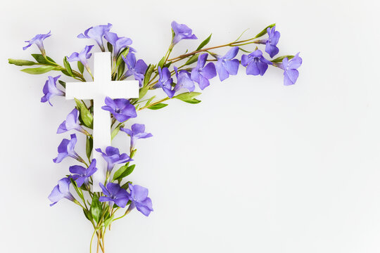 The Christianity cross of beautiful blue periwinkle flower. Baptism, Easter, church holiday background