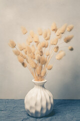 Vase of dried soft autumn flowers. Rabbit Tail Grass. vintage foto