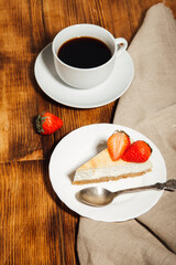 Classic vanilla cheesecake (New York cheesecake) with strawberries on a white plate 