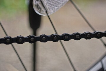 Fototapeta na wymiar long black iron chain and gray knitting needles on a bicycle