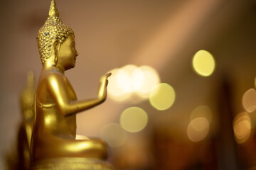 Ancient golden buddha with bokeh as background