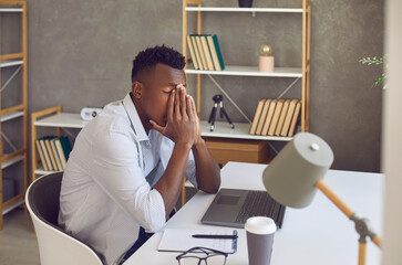 Upset black man overwhelmed with problems, financial difficulties or stress and negativity at work....