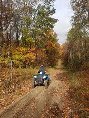 ATV riding in fall forest in Ontario mid October on dirt trails through woodlots © Janet