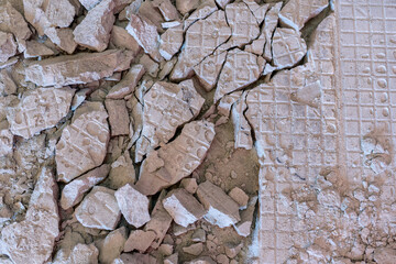 Broken floor tiles and old tiling mortar is a cracked adhesive mortar by the technicians preparing new floor tiles again in the same area.