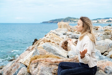 Blonde woman in lotus pose doing breathing pranayama exercise. Outdoor workout. Mindfulness zen spiritual meditation tips. Kundalini yoga. Reiki meditation. Relaxing. Unity with nature