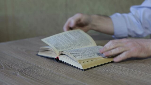 The man is tearing the pages of the book.