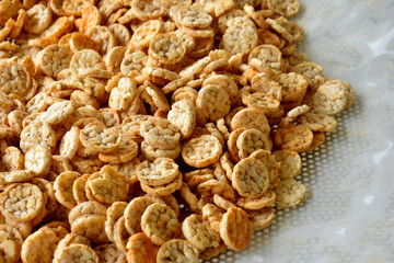 Popped Japanese brown rice is ground into powder, then made into a round disk, then crispy until golden brown and then dried. 