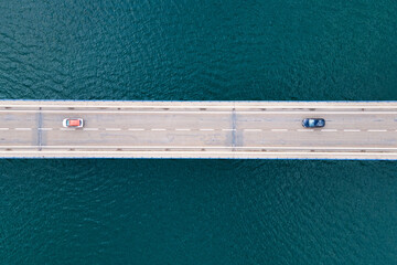 Aerial view of bridge road with cars over lake or sea. High quality photo.