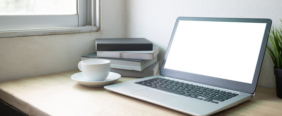 Laptop computer with white blank screen on wood desk. Workspace, workplace, desktop office concept.