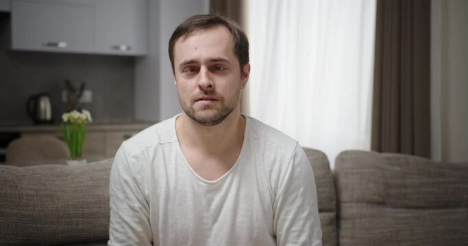 Silly man making faces on sofa