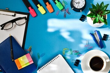 Office and school supplies on a blue background. Flatlay, copy space