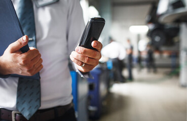 Master receptionist in a car service station with a tablet for recording repairs and maintenance. Repair area, telephone consultation, diagnostics, car maintenance. Copy space