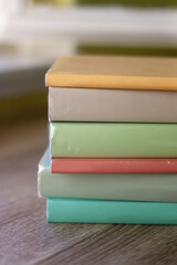 Stack of colorful books on a table. Selective focus.