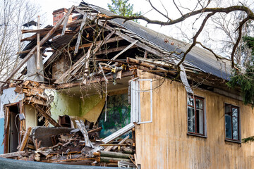 Demolition of an old two-story wooden house. Half destroyed building