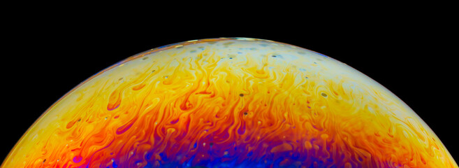 Rainbow colors created by soap, bubble,or oil on black background
