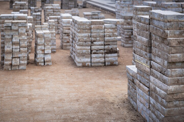 Pavement repair and laying of paving slabs on the walkway, stacked tile cubes on the background. Laying paving slabs in the pedestrian zone of the city, sand filling. Road tiles and curbs