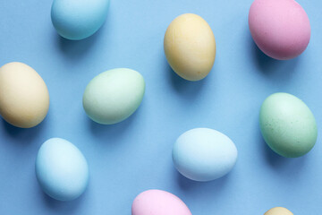 Easter holiday. Painted Easter eggs on a blue background. Pastel colors. Festive background with colorful eggs. Easter egg hunt game. Tradition.