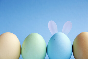 Easter holiday. Painted Easter eggs on a blue background. Pastel colors. Festive background with colorful eggs. Easter egg hunt game. Tradition.