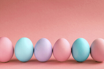 Easter holiday. Painted Easter eggs on a red background. Pastel colors. Festive background with colorful eggs. Easter egg hunt game. Tradition.