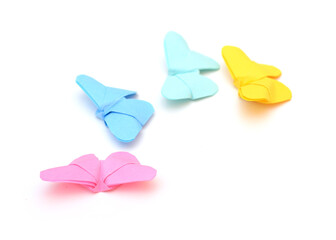 Four colorful origami butterflies leading on white