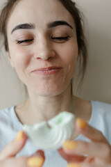 Young woman eating marshmallow. Pretty caucasian woman smiling. Sincere emotions. facial expressions