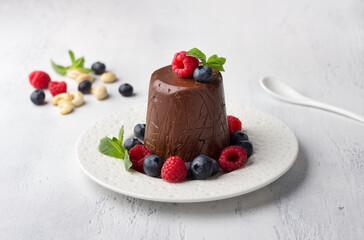 Vegan cashew and chocolate Easter paskha, delicious dessert with berries and mint on light blue background