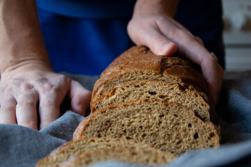 Front view of man's hands holding bread loafs on table
