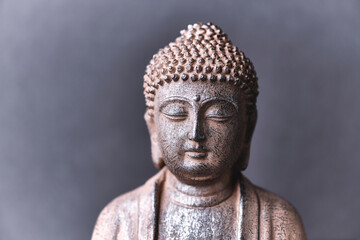 Meditating Buddha Statue on paper background. Close up. 