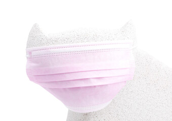 Pink face mask on cat figure's face. Coronavirus preventive.