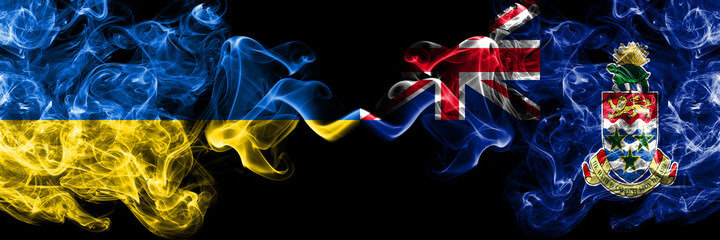 Ukraine, Ukrainian vs British, Britain, Cayman Islands smoky mystic flags placed side by side. Thick colored silky abstract smokes flags.