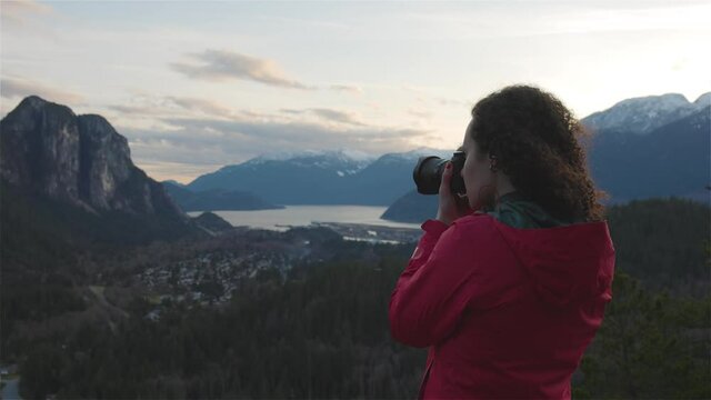 Adventure Travel Photographer Hiking in the mountains and taking pictures during a Spring Sunset. Squamish, North of Vancouver, British Columbia, Canada. Slow Motion