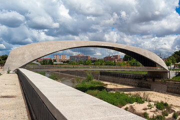 Fototapeta premium Madrid, Spain- April 30, 2021: Bridges over the Manzanares river in Madrid. Constructions next to the river. Urban photo