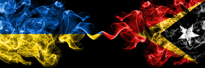 Ukraine, Ukrainian vs East Timor, Timorese smoky mystic flags placed side by side. Thick colored silky abstract smokes flags.