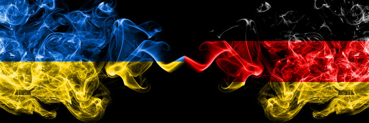 Ukraine, Ukrainian vs Germany, German, Deutschland smoky mystic flags placed side by side. Thick colored silky abstract smokes flags.