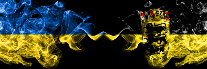 Ukraine, Ukrainian vs Germany, German, Deutschland, Baden Wurttemberg smoky mystic flags placed side by side. Thick colored silky abstract smokes flags.