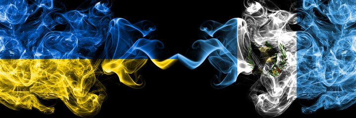 Ukraine, Ukrainian vs Guatemala smoky mystic flags placed side by side. Thick colored silky abstract smokes flags.