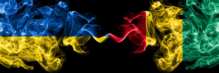 Ukraine, Ukrainian vs Guinea smoky mystic flags placed side by side. Thick colored silky abstract smokes flags.