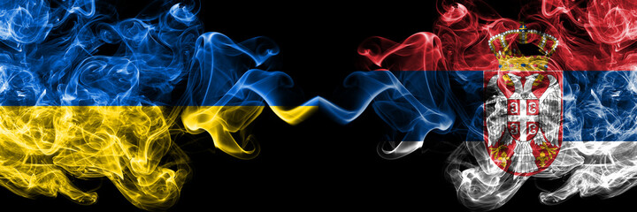 Ukraine, Ukrainian vs Serbia, Serbian smoky mystic flags placed side by side. Thick colored silky abstract smokes flags.
